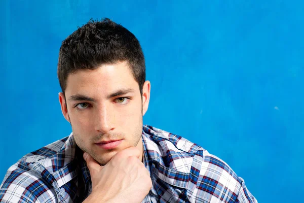 Schöner junger Mann mit kariertem Hemd auf blau — Stockfoto