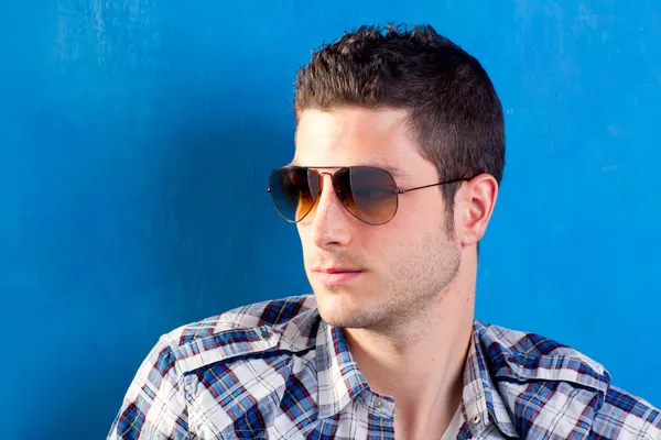 Homem bonito com camisa xadrez e óculos de sol — Fotografia de Stock