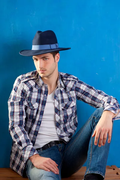 Hombre guapo con camisa a cuadros y sombrero de vaquero — Foto de Stock