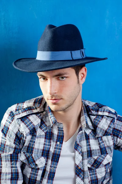 Przystojny mężczyzna z plaid shirt i kowbojski kapelusz — Zdjęcie stockowe