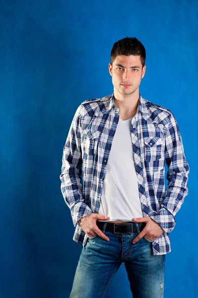 파란색에서 체크 무늬 셔츠 데님 청바지와 잘생긴 젊은 남자 — 스톡 사진