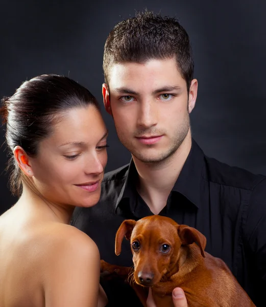 Couple in love with brown little pet puppy dog — Stock Photo, Image