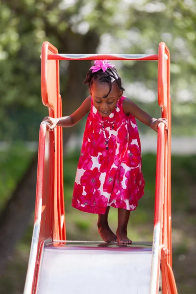 Portret van een schattig Afro-Amerikaanse klein meisje spelen op playg — Stockfoto