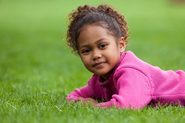 Portrait of a Adorable little African Asian girl lying down on — Stock Photo, Image