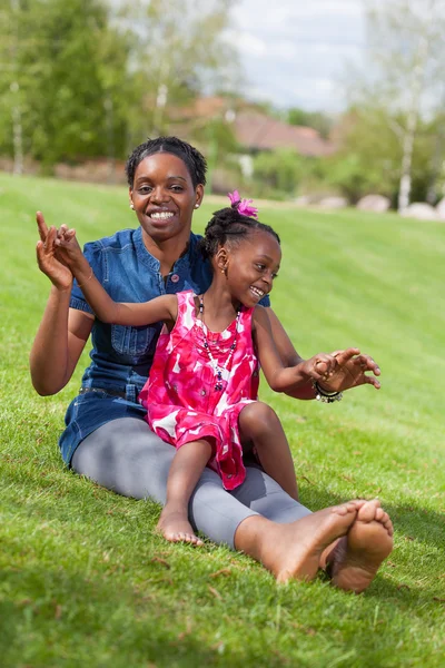 Adorable african mother with her daughter in the garden — Stock Photo, Image