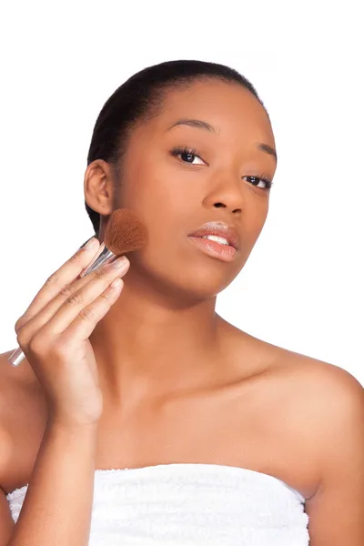 Retrato de uma jovem mulher africana bonita aplicando maquiagem, isolado sobre — Fotografia de Stock