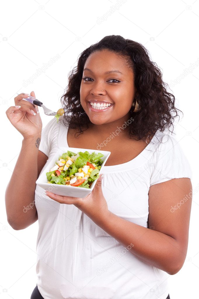 Young african american woman eating salad