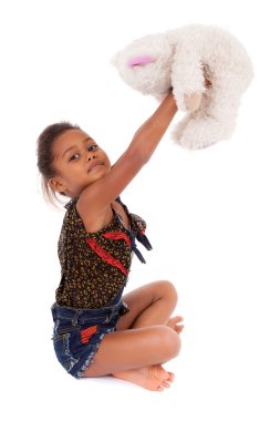 Cute little African Asian girl playing with a teddy bear clipart