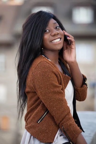 Retrato de una joven adolescente negra feliz usando un pho móvil —  Fotos de Stock