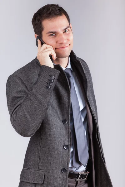 Portret van een jonge Kaukasische zakenman met behulp van een mobiele telefoon — Stockfoto