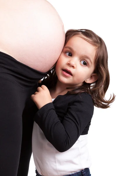 Felice figlia abbracciare il suo incinta madre pancia — Foto Stock