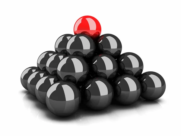 Pyramid of black spheres and top red sphere leader — Stock Photo, Image
