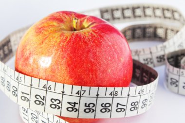 Red fresh apple and measure tape. diet concept clipart