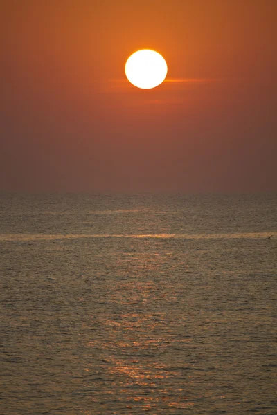 Röda solen vid solnedgången — Stockfoto