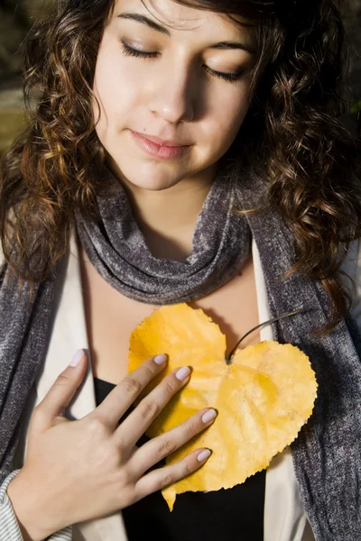 Beautiful girl with yellow leaf — Stock Photo, Image