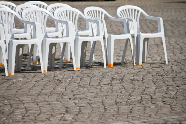 Cadeiras de plástico branco alinhado — Fotografia de Stock