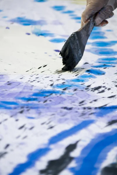 Hand schildert een kleurrijke doek. — Stockfoto