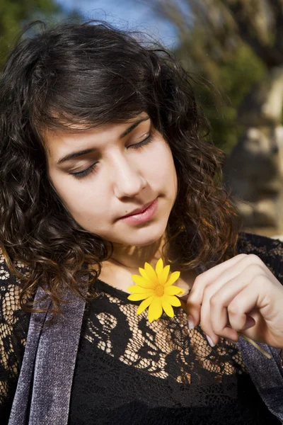 Vacker flicka med gul blomma — Stockfoto