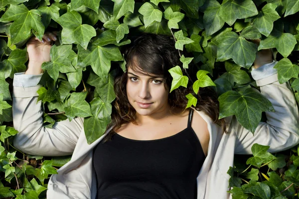 Bella ragazza circondata da foglie verdi — Foto Stock