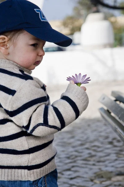 Barn med mössa och blomma — Stockfoto