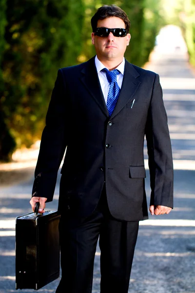 Homem de negócios com mala em uma estrada — Fotografia de Stock