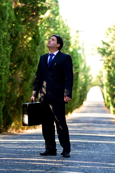 ビジネスの男性と、道路上のスーツケース — ストック写真
