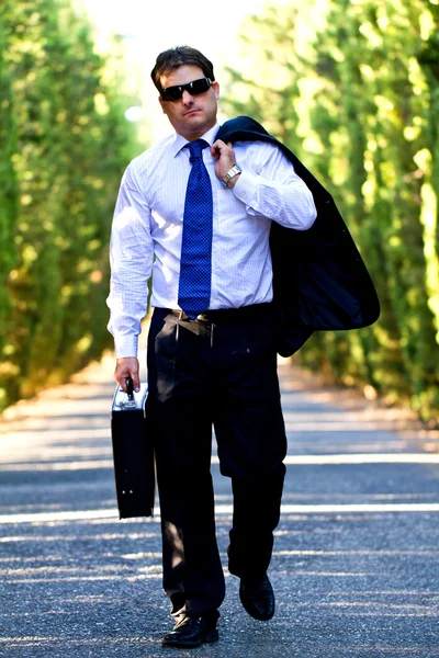 stock image Business man with suitcase on a road