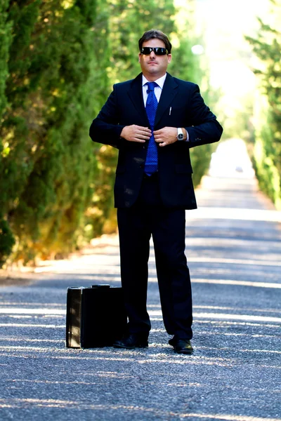 Homme d'affaires avec valise sur une route — Photo
