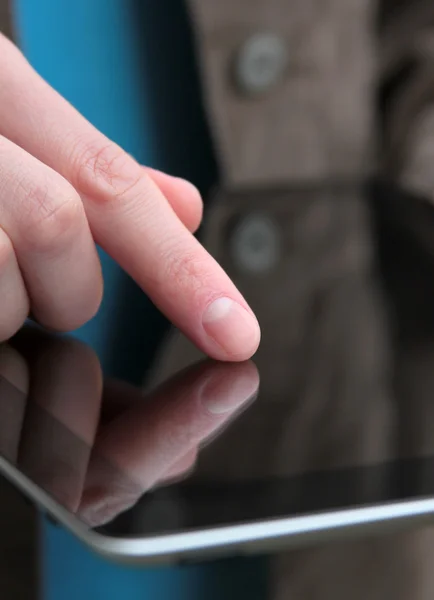 Палец на экране планшетного компьютера — стоковое фото