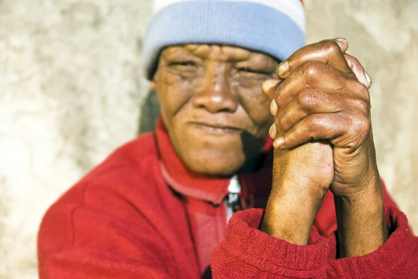 stock image An old African woman with folded hands - focus on the weathered hands