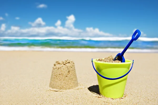 Hračky kbelík a rýč na pláži — Stock fotografie