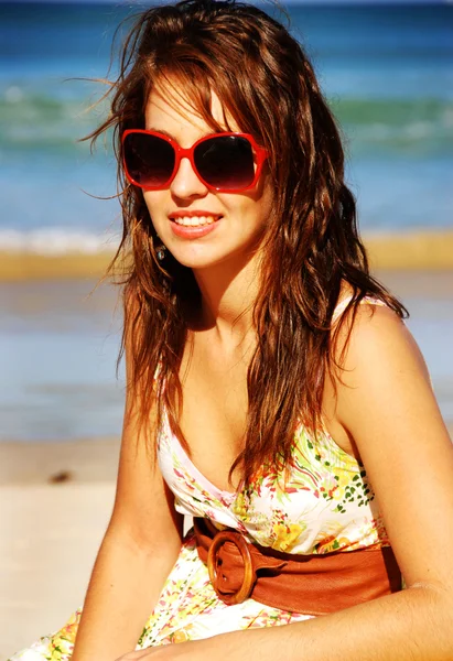 Hübsches Mädchen mit roter Sonnenbrille am Strand — Stockfoto