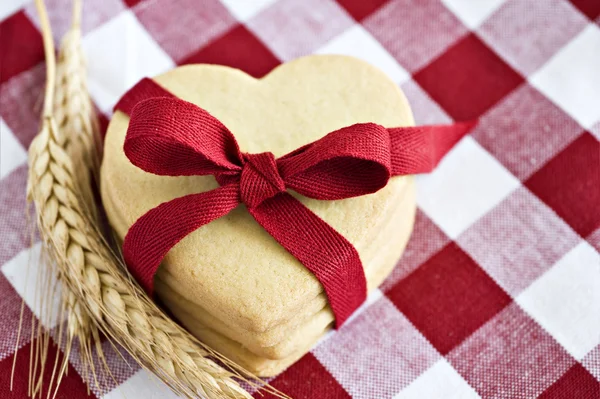 Cookies em forma de coração com uma fita vermelha — Fotografia de Stock