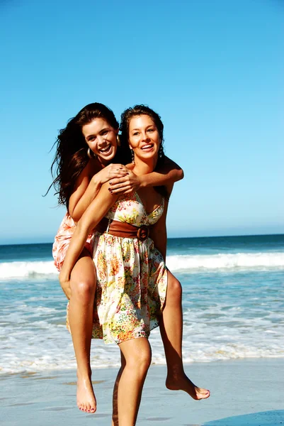 Hermosas mujeres jóvenes jugando en la playa —  Fotos de Stock