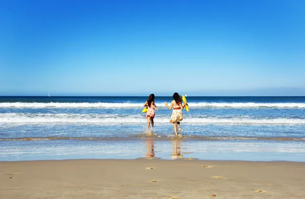 Vackra unga kvinnor som spelar på stranden — Stockfoto