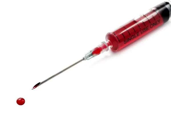 Syringe and needle filled with blood Royalty Free Stock Photos