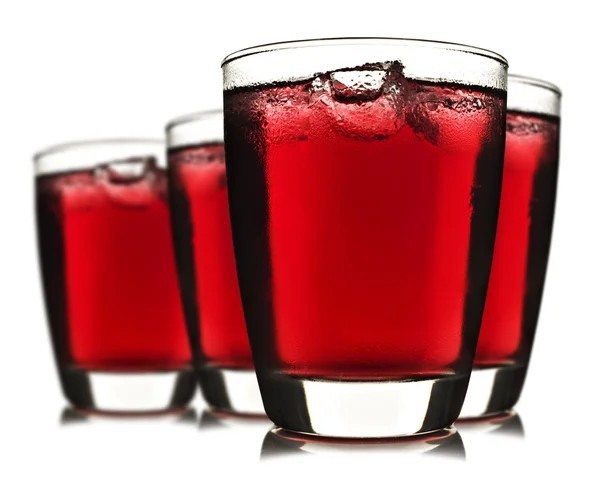 Čtyři sklenice červené ovocné šťávy s ledem — Stock fotografie