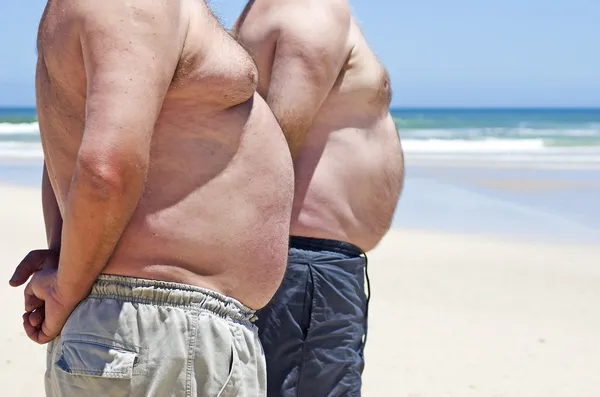 Närbild på två feta fett män på stranden — Stockfoto