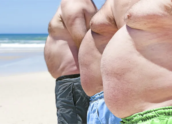 Nahaufnahme von drei fettleibigen dicken Männern am Strand — Stockfoto