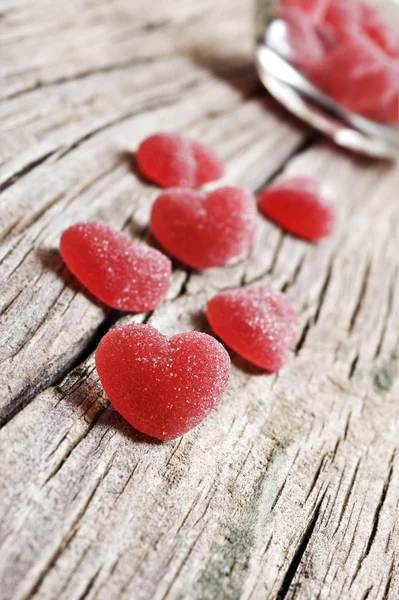 Doces de geleia em forma de coração vermelho em um fundo rústico — Fotografia de Stock