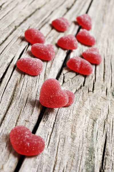 Red heart shaped jelly sweets on a rustic background — Stock Photo, Image
