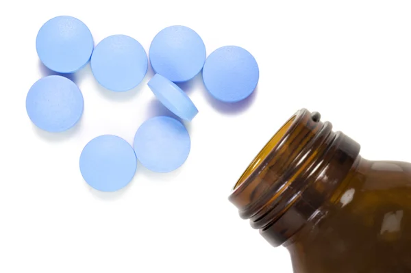 Tabletta és pirulát üveget a hely a szöveg fehér háttéren — Stock Fotó