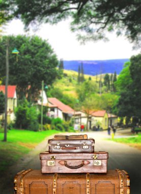 Traveling suitcases in a small town street clipart