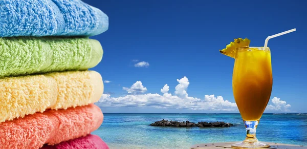 Kolorowe ręczniki i koktajl owoców na plaży — Zdjęcie stockowe