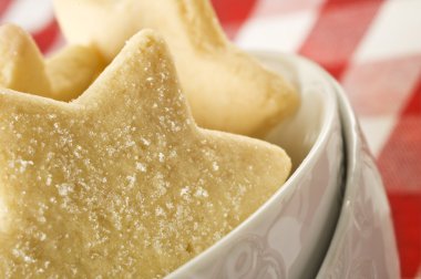 Sugar coated shortbread cookies in star shapes stacked up - on a white background with space for text clipart