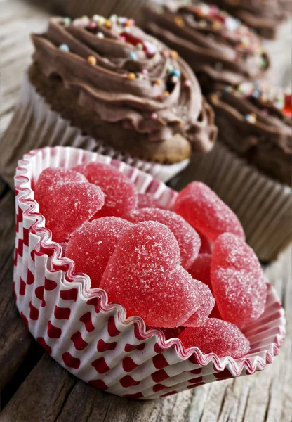 Červené srdce želé cukrovinky, čokoládové košíčky — Stock fotografie