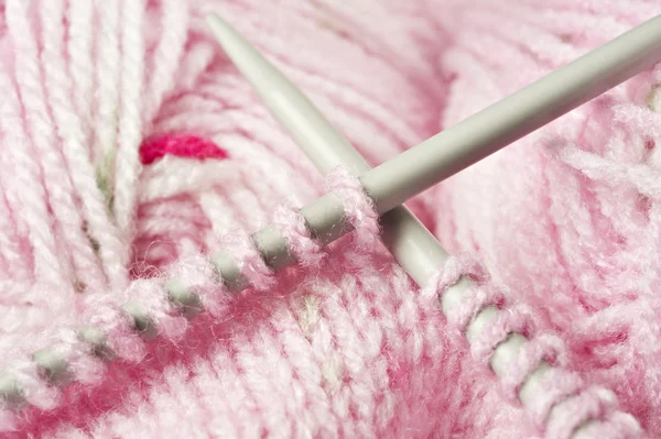 Een baby van de roze trui - breien garen en pennen — Stockfoto