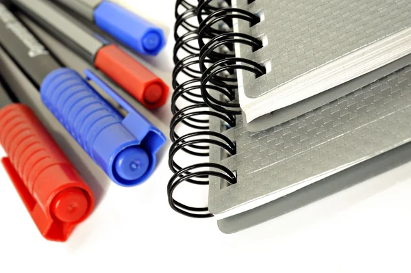 Notebook neri e penne colorate su sfondo bianco con spazio per il testo — Foto Stock