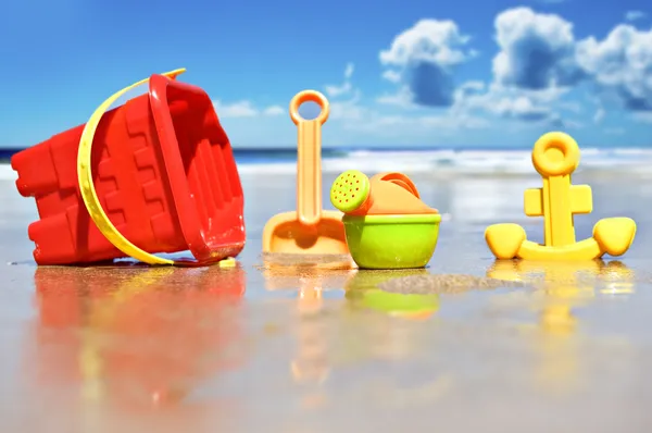 Крупный план детских пляжных игрушек на пляже - сфокусируйтесь на банке для полива — стоковое фото