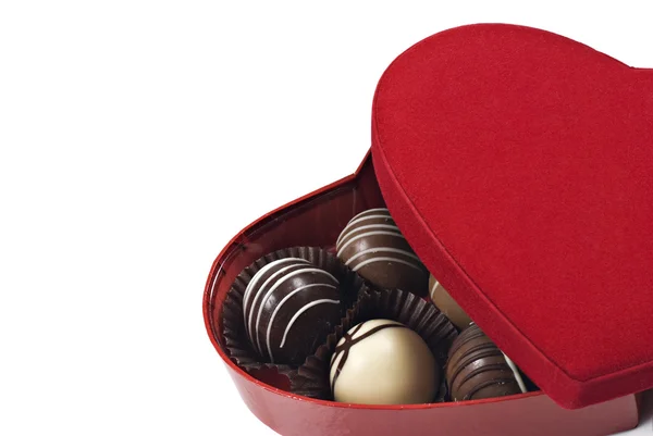 Uma caixa em forma de coração vermelho de chocolates em um fundo branco com espaço para texto — Fotografia de Stock